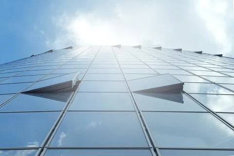 Facade of modern skyscraper with reflection of cloudy sky and sunbeams, Stock Photos
