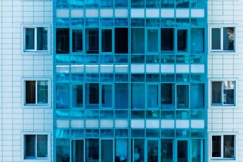 Facade of a modern urban multi-storey apartment house with blue windows. Stock Photos