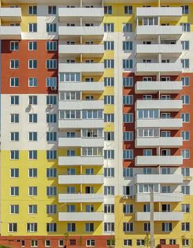Facade of a modern yellow multi-storey residential building Stock Photos
