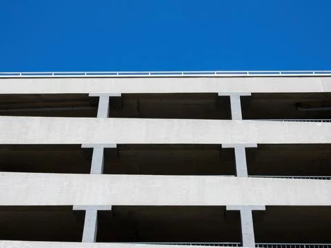 Facade of a multi-level car parking on a background of blue sky Stock Photos