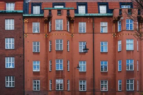 Facade of a multi-storey building with people in the Windows Stock Photos