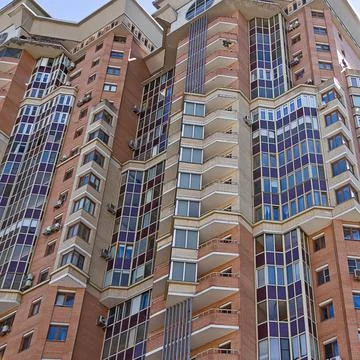 Facade of a multi-storey modern building. Typical city development. Stock Photos