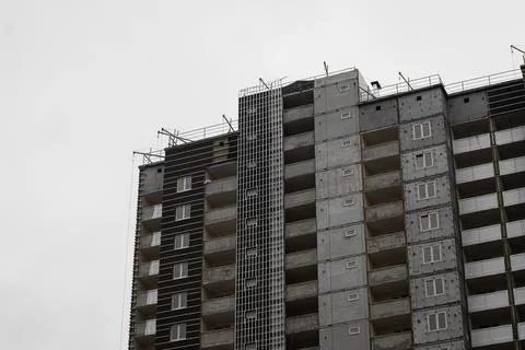 Facade of a multi-storey panel house in the process of wall decoration. Stock Photos