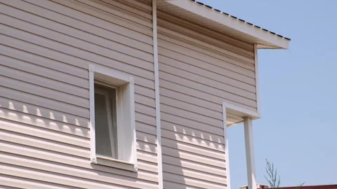 The facade of the new house clad with siding, with windows, against the blu.. Stock Footage 246749407