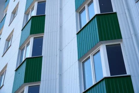 Facade of a new multi-storey building with white and green metal siding, many Stock Photos