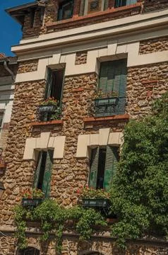 Facade of old brick building with flowers at Montmartre in Paris Stock Photos
