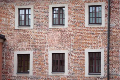 The facade of an old brick building with windows or cornices. Old brick walls Stock Photos