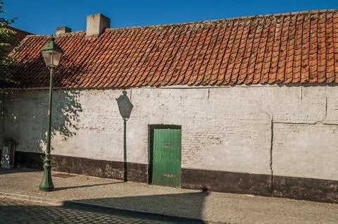Facade of old brick house at empty street of Damme Stock Photos
