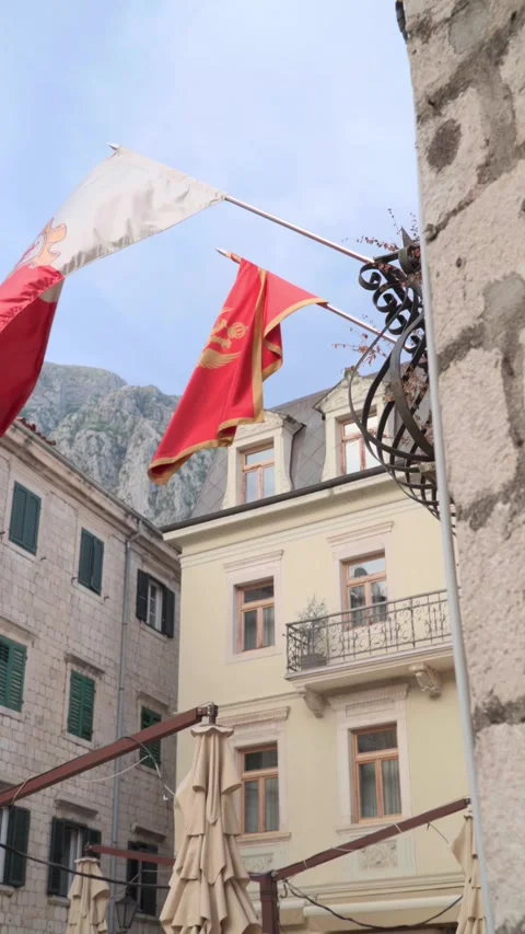 Facade of an old building, balcony and waving flags Stock Footage 281737512
