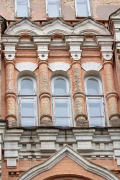 Facade of the old building with columns and arched windows Stock Photos
