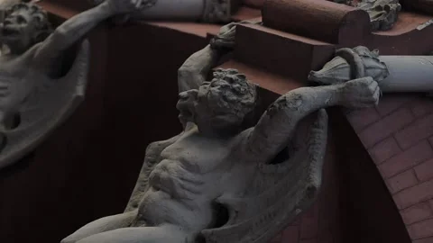 Facade of an old building decorated with a gargoyle figure Stock Footage 232875762