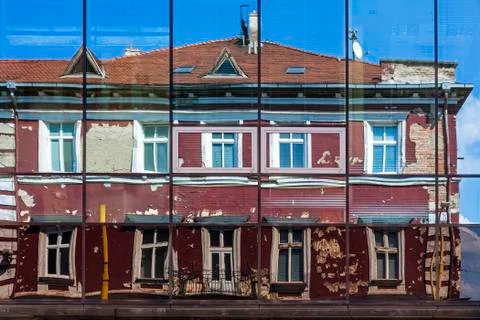 Facade of old building reflected in the windows of modern Hotel Stock Photos