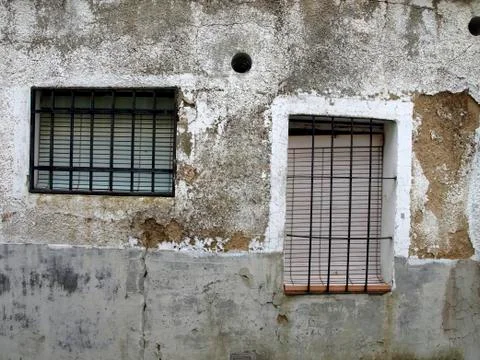 Facade of old building with two windows in Spanish town Stock Photos