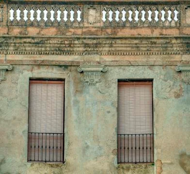 Facade of old building with two windows in Spanish town Stock Photos