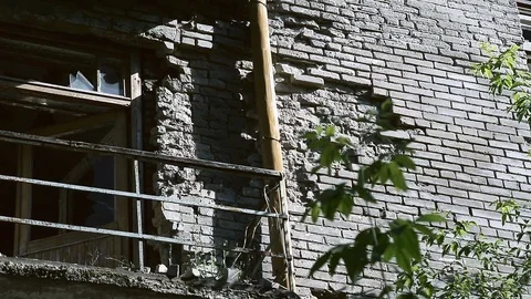 The facade of the old destroyed brick building with broken windows in the Vídeos de archivo 110433421