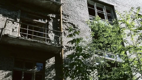 The facade of the old destroyed brick building with broken windows in in ghetto Stock Footage 110437197