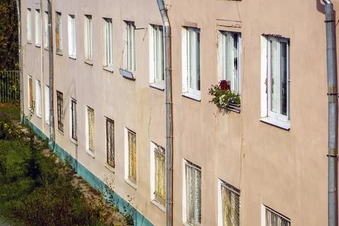 The facade of the old house on one of the windows are flowers Stock Photos