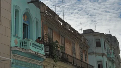 The facade of an old two-story building with balconies in Havana. Curly green Stock Footage 228860985