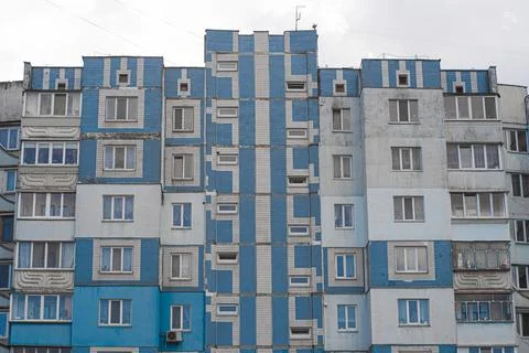 Facade of a panel apartment building of a Soviet house lined with blue tiles. Stock Photos
