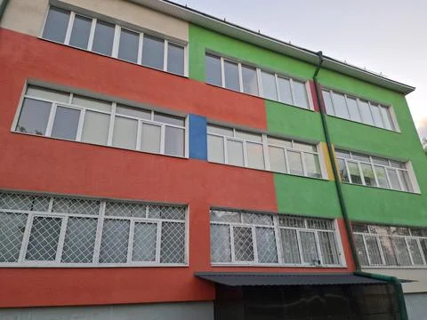 Facade of school building with windows and many-coloured wall Fotos de archivo