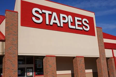 The facade of a Staples store with it's large red sign with white lettering Stock Photos