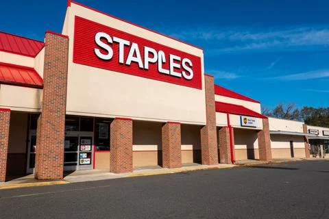 The facade of a Staples store with it's large red sign with white lettering Stock Photos