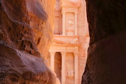 Facade of a temple in Petra, Jordan appearing from a canyon rocks Stock Photos