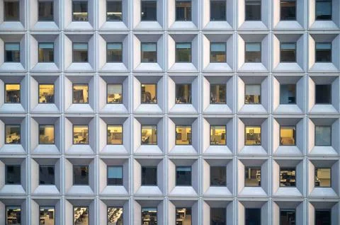 Facade of urban skyscraper with rows of square geometric windows Stock Photos