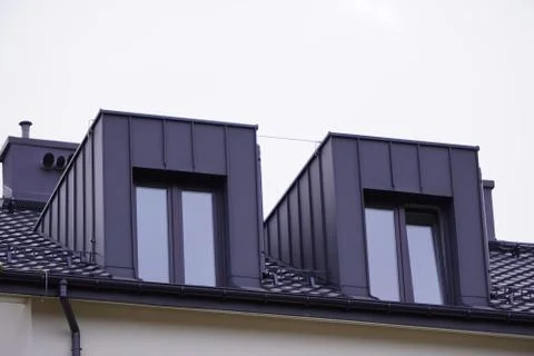 Facade of windows in attic or loft housing or office. Apartments under the ro Stock Photos