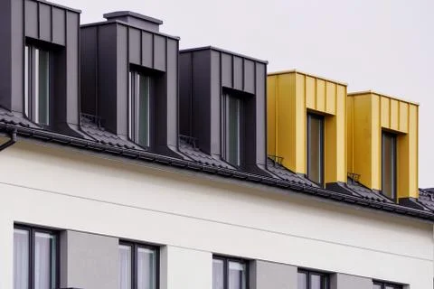 Facade of windows in attic or loft housing or office. Apartments under the ro Stock Photos