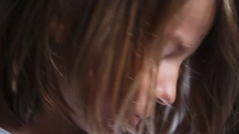 The face of a 10-year-old boy with light, long hair reflects the enthusiasm and Stock Footage 249256844