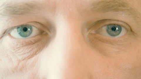 Face and eyes of elderly man winking and looking to camera. Close up male eyes Stock Footage 102570136