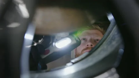 Face of an auto mechanic during the inspection of the brake system Stock Footage 221547552