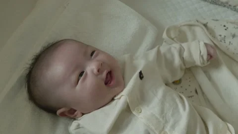 The face of a baby smiling broadly while looking at the mobile. Stock Footage 194708242
