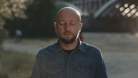 Face of a bald man in the park. He is putting his mask on. Stock Footage 135077455
