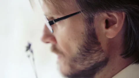 The face of a bearded man wearing glasses with a flower in her hand. Stock Footage 52321872