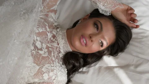 Face Of Beautiful Bride On Her Wedding Day. Girl Lying In Bed. Top View. Stock Footage 153712499