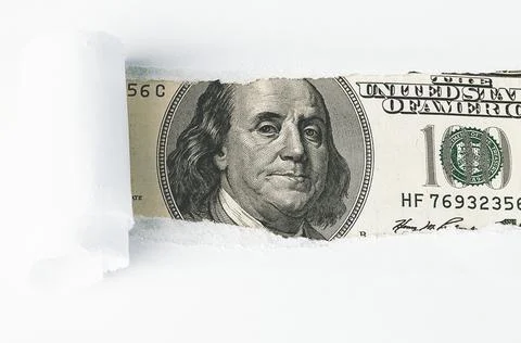 The face of Benjamin Franklin on a hundred-dollar bill, from a torn window in Stock Photos