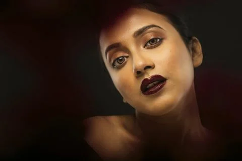 Face of a beutiful female model behind a bunch of red flowers shot in a stu.. Stock Photos