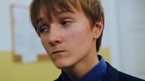 Face boy eats waffles at school look around background in classroom break meal Stock Footage 99255746