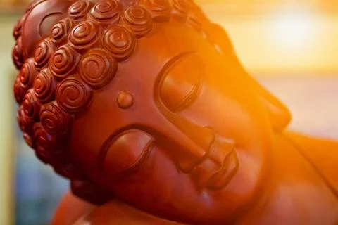 The face of Buddha, against the backdrop of the sun. Stock Photos