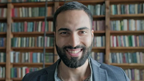 Face Of Cheerful Guy With Beard In The Library. Stock Footage 139891107