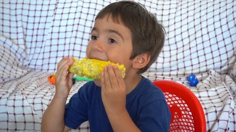 Face of child eating boiled corn and watching TV 2 Stock Footage 93987671