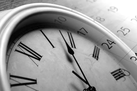 Face clock and sheet of a calendar with the number of days Stock Photos