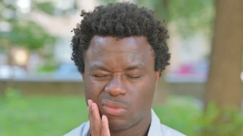 Face Close up of African Man with Toothache Outdoor 動画素材 316807161
