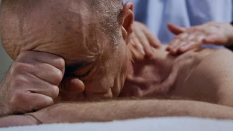 Face Closeup of Senior Male Client Enjoying Neck Massage by Professional Masseur 库存影片 311423637