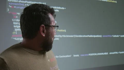 Face of Coding Teacher Demonstrating Computer Script Projected on Wall Stock Footage 318713919