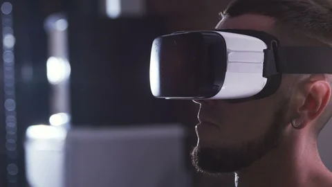 Face of concentrated young man in virtual reality goggles looking straight. Guy Stock Footage 98179319