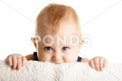 Face of curious baby peeping out of board over white background Stock Photos