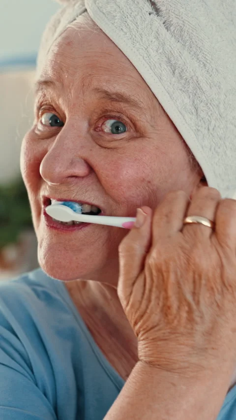 Face, elderly or woman brushing teeth with toothbrush in bathroom for dental Stock Footage 333163606
